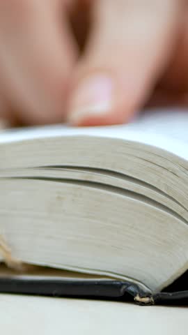 Holy Bible lays open. Woman hand follows scripture and Christian faith. Finger moves along sacred text. Prayer reflection and study of divine teachings. Spiritual wisdom strengthens soul