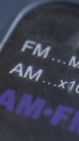 Old radio panel displays FM and AM frequency range in megahertz and kilohertz. Idea of forgotten media. Nostalgia of simpler times. Focus on tactile interface and manual control