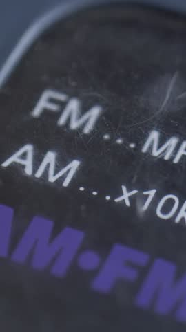 Old radio panel displays FM and AM frequency range in megahertz and kilohertz. Idea of forgotten media. Nostalgia of simpler times. Focus on tactile interface and manual control