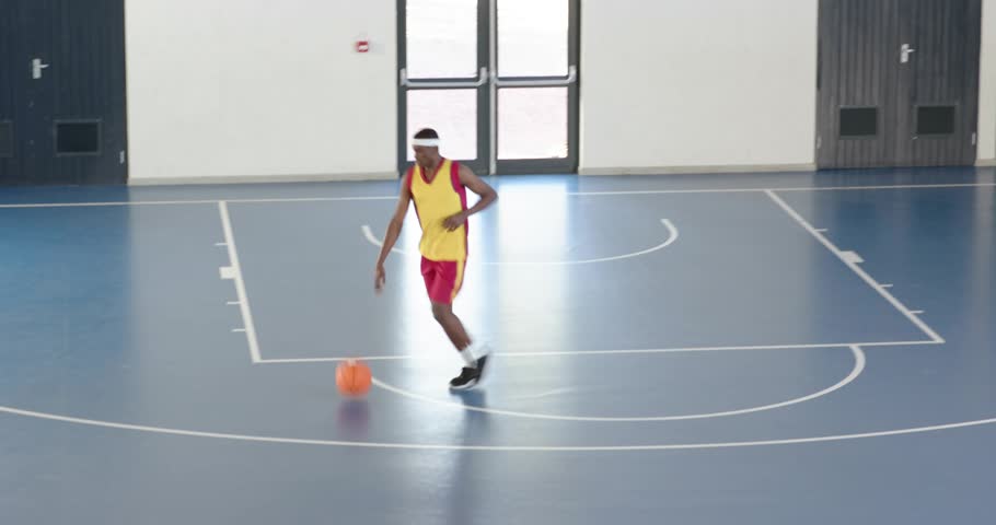 Sports player holding ball at key, dribbling and driving to hoop to score, particles highlight shot. Basketball, athlete, promo, dynamic, neon, overlay, glow