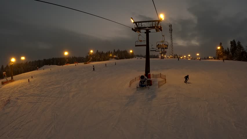 Snowboarding at night on a ski slope in winter