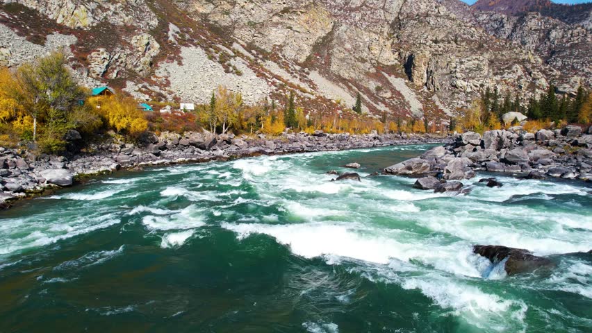 Fast Flowing River, Rapid Water Flows Past Rugged Stones Among Vivid Trees, Energetic River Torrents Move Rapidly Past Jagged Rocks Amidst Vibrant Autumnhued Forests Surrounding Steep Valleys