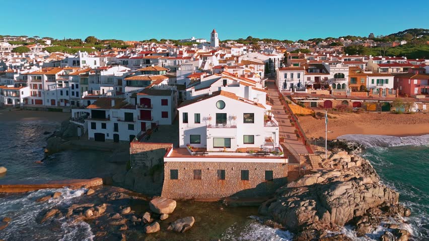 Aerial view of the charming village of Calella de Palafrugell at sunrise in Catalonia, Costa Brava, Spain. Scenic coastal townscape with traditional architecture and tranquil morning light.