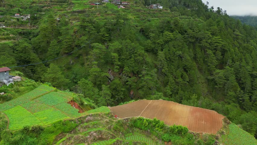 Rising forward aerial gliding over the winding highway toward tiered rice terraces as they meet the thick, low-hanging clouds of Buguias, Benguet.