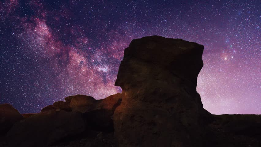 Beautiful night landscape, mountains under colorful bright milky way galaxy at starry night. Time lapse