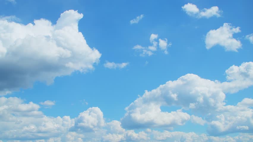 White cumulus clouds move across the blue sky. Meteorological background.