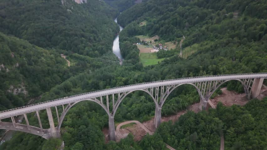 Breathtaking drone shot of a monumental bridge between lush green mountains, Montenegro summer landscape