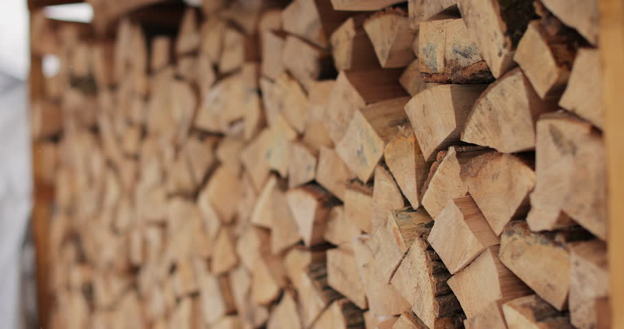 Close-up of a large pile of chopped dry wood for a fireplace or stove. Logs for the fire. Harvesting dry firewood for the winter.