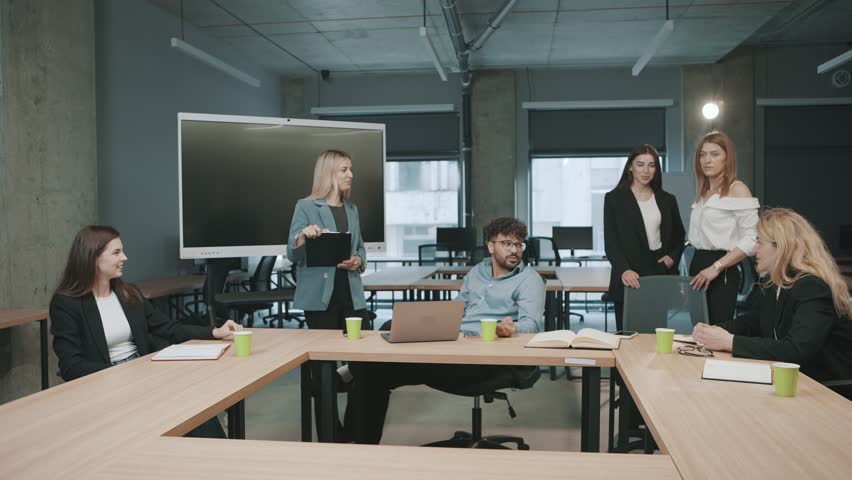 Colleagues discuss project plans in a modern office space during a team meeting