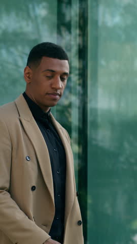 Cool rich African American business man walk city outdoors office building male employer CEO businessman putting on stylish sunglasses confident fashionable guy urban style career success modern look