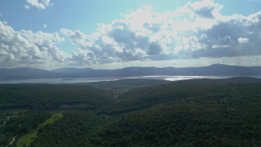Aerial Drone View Of Green Hills And Coastline Under Dramatic Clouds