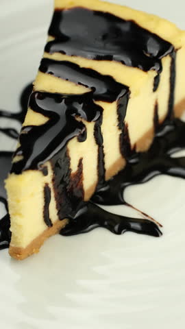 Slice of cheesecake with Chocolate sauce on plate, rotation