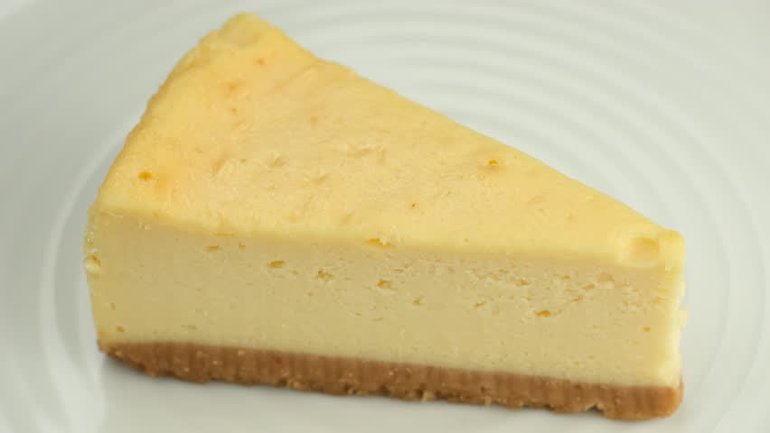 Chocolate sauce pouring on slice of cheesecake.  Cheesecake with chocolate sauce