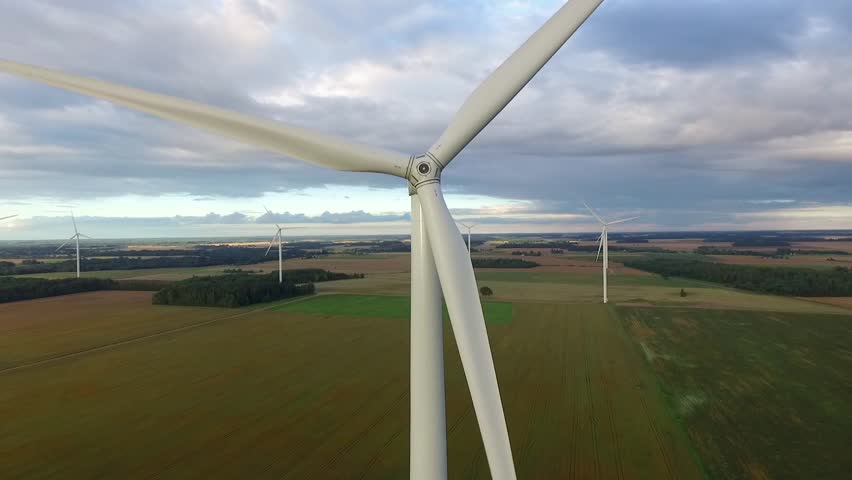 Windmills in Beautiful Nature, Landcape. Sustainable power. Aerial view of wind turbines. Alternative Eco Energy Wind Turbine in Beautiful Green Landscape at Sunset. Aerial drone view