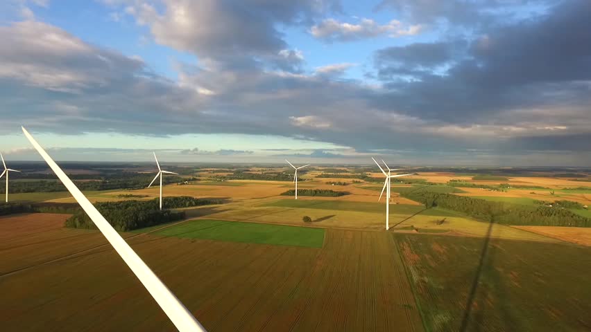 Windmills in Beautiful Nature, Landcape. Sustainable power. Aerial view of wind turbines. Alternative Eco Energy Wind Turbine in Beautiful Green Landscape at Sunset. Aerial drone view