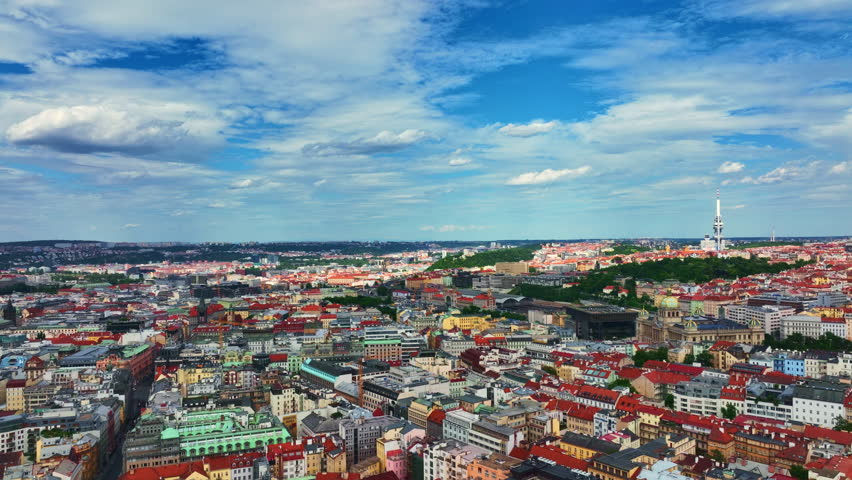 Prague city across red rooftops. Prague urban pattern from above. Prague historic districts with modern landmarks. Prague capital of Czech.