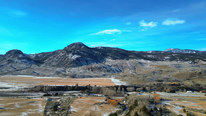 Aerial sideways with pan of snowy mountains near Yellowstone