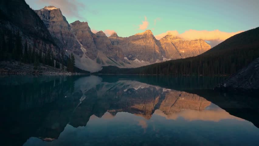 Stunning Reflection of Rocky Mountains in Calm Alpine Lake at Sunrise