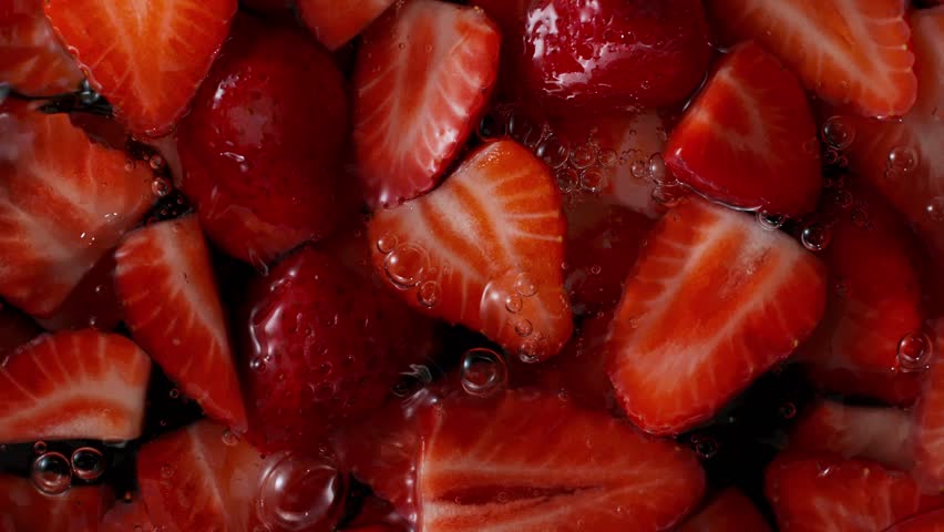 Super Slow Motion Shot of Fresh Strawberries Falling into Water at 1000fps.