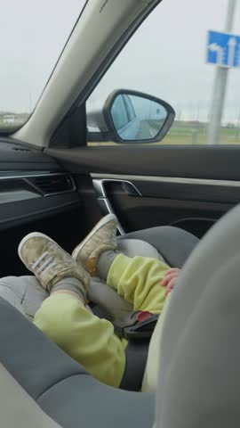 Baby in car seat in modern car interior. Daylight through window during short road trip. Secure harness. concept of infant safety in a child seat. peaceful atmosphere and gentle motion during drive