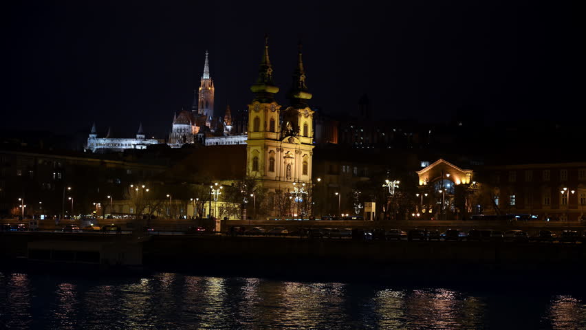 Illuminated historic church towers and Castle Hill architecture at night in Budapest, Hungary