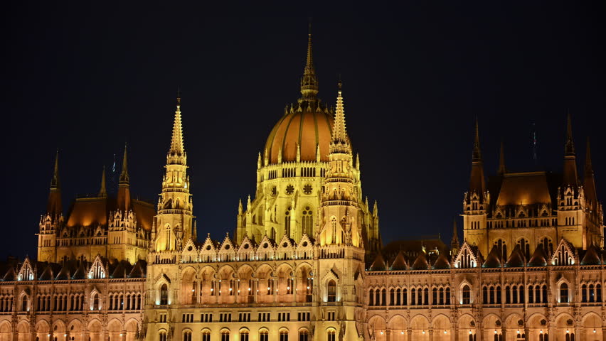 Close-up view of the illuminated Hungarian Parliament dome and spires at night in Budapest, Hungary