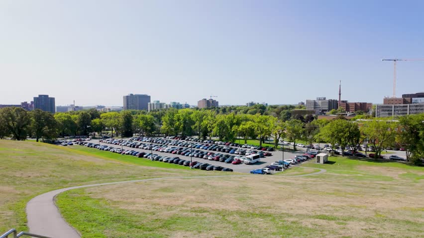 Slow motion footage from Halifax Citadel National Historic Site in Halifax Nova Scotia Canada overlooking the city skyline with a large car park green parkland modern buildings and a clear blue sky on a sunny day