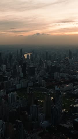 Twilight view of Bangkok city skyline with glowing lights from high rise buildings and fading sunlight. Bangkok, Thailand.