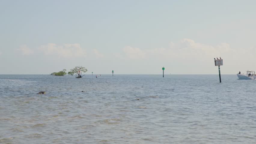Shot of boat and signs in the ocean at Biscayne National Park, Florida. Calm waters and clear skies make this ideal for marine, boating, or nautical projects.