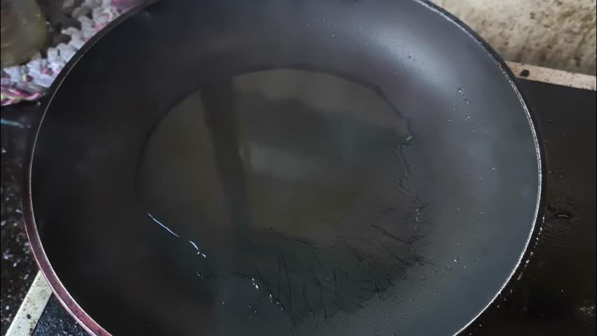 Frying eggs in pan, indoor Chiangmai Thailand.