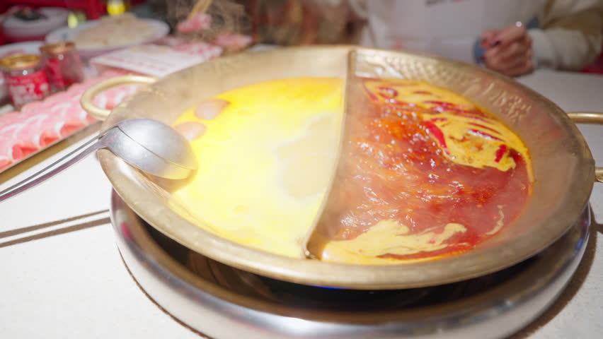 Woman tourist eating traditional hot pot or mala spicy soup in restaurant. Popular foods for tourist eating in Chengdu, Chongqing and China. Chinese Asia and Sichuan foods concept