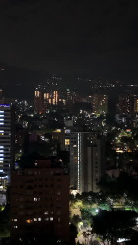 Explore a captivating aerial view of Medellin’s El Poblado at night. This vertical video beautifully captures urban lights and skyline, perfect for mobile and social media use.