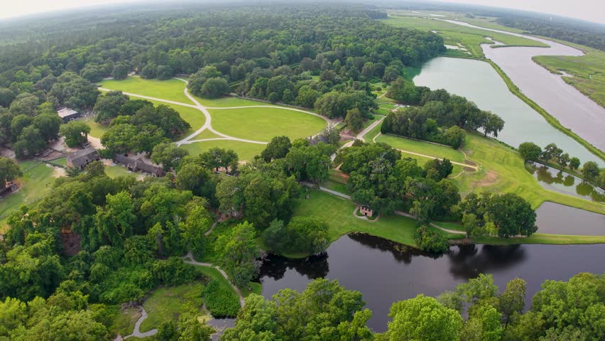 Drone footage of Middleton Place Plantation shows landscaped grounds with ponds, lawns, and tree-lined paths near Charleston, South Carolina
