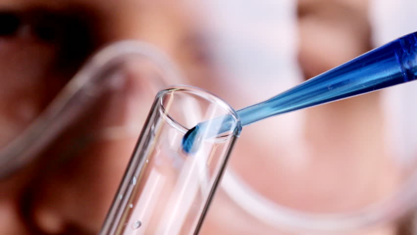 Close up HD video of scientist putting drops of chemical into test tube