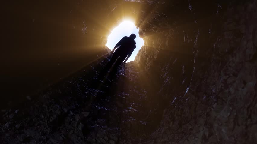 Person walking through an ancient stone tunnel, evoking history, exploration, adventure, mystery, and atmospheric architectural surroundings.