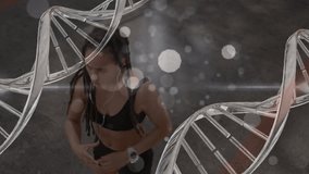 Animation of dna strands and light spots over woman exercising. Global sport, healthcare and digital interface concept digitally generated video. - Powered by Shutterstock - Get 15% off with code: PIKWIZARD15