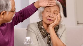 Caring senior husband touches wife's forehead to check for fever in their living room. - Powered by Shutterstock - Get 15% off with code: PIKWIZARD15