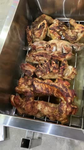 Shot of a person preparing and cooking meat in a traditional Chinese box oven. Slow cooking process with charcoal in an outdoor setting.