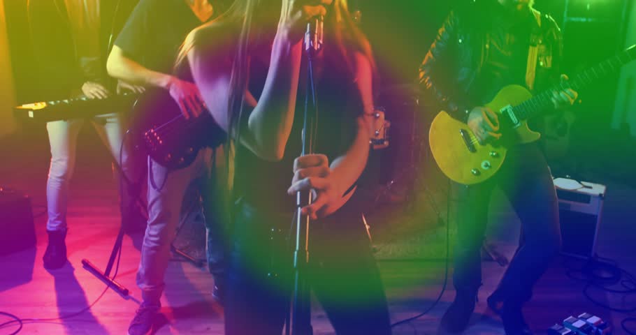 Band performing under vivid music stage lights, with animated EQ bars and microphone icons. Live music, concert, entertainment, stage performance, musical ensemble, vibrant lighting, sound engineering