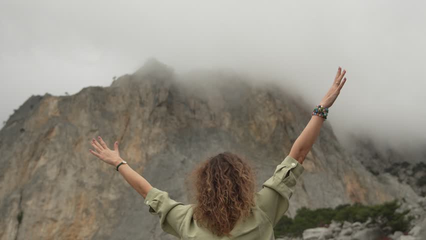 Freedom Hiking Mountain Woman celebrates achievement with raised arms on misty peak Vertical video.