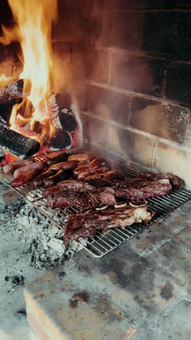 Sausages, steaks, and beef ribs are being grilled. Summer bbq party. Vertical footage. High quality 4k footage