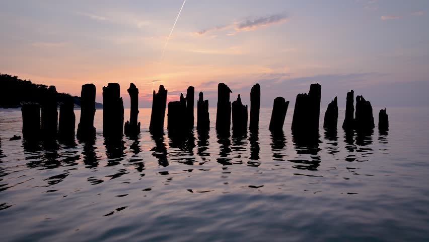 Wooden breakwater during sunset over Baltic Sea beach in Debki village, Pomerania region of Poland