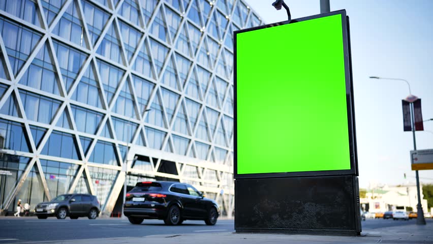 Green screen billboard for advertising mockup on urban street with modern building