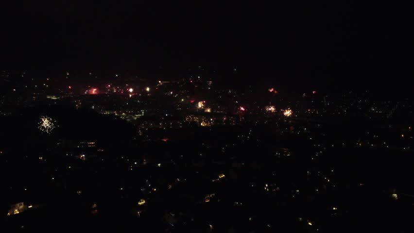 Spectacular aerial view of a city valley covered in colorful fireworks during New Year