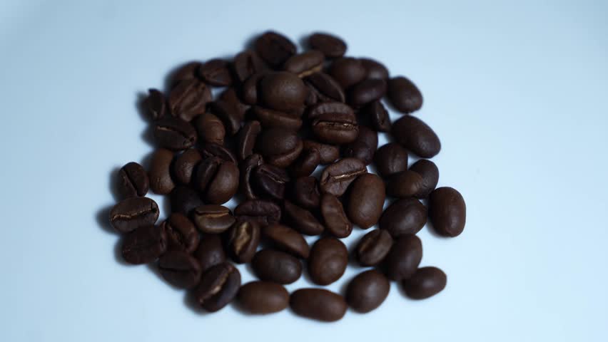 Close up of seeds of coffee. Fragrant coffee beans are roasted smoke comes from coffee beans, with cup coffee