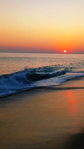 Golden Sunset over Ocean Horizon with Rolling Waves on Sandy Coast