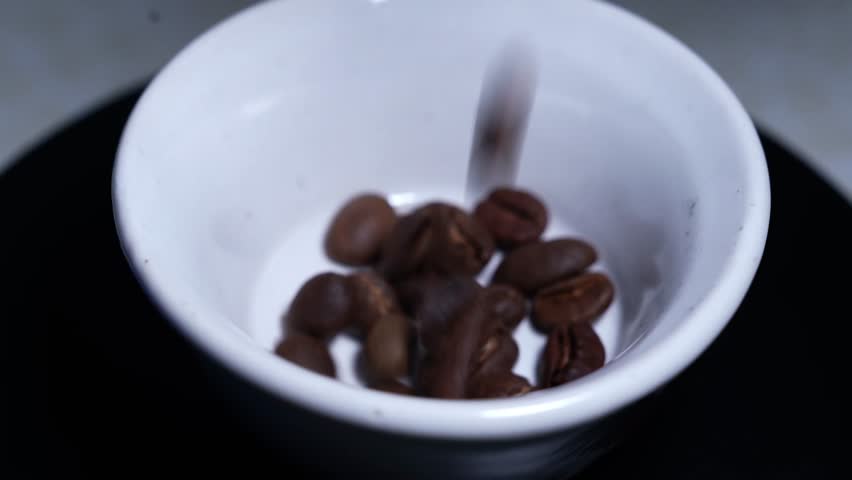 Close up of seeds of coffee. Fragrant coffee beans are roasted smoke comes from coffee beans, with cup coffee