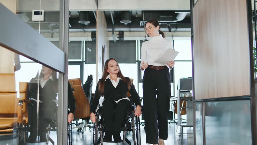 Team members discuss plans for a project in a modern coworking space focusing on inclusion and accessibility for all professionals