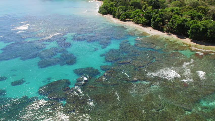 Aerial view of turquoise reef lagoon and sandy tropical shoreline in Costa Rica