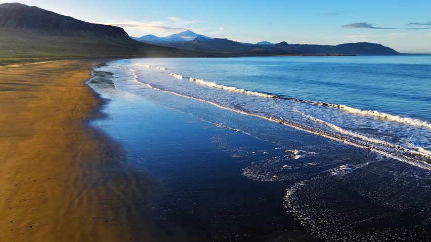 Cinematic Sunrise over Black Sand Volcanic Beach with Crashing Waves, Serene and Tranquil Landscape. Iceland.